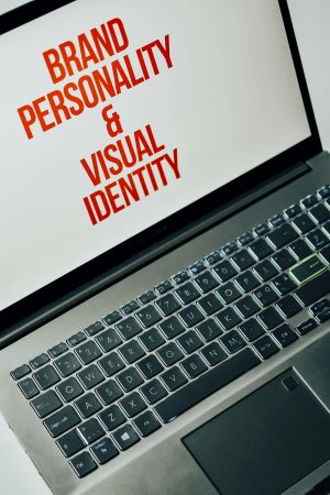 ordinateur portable ouvert avec les mots images de marque et identite visuelle ecrits en rouge sur fond blanc